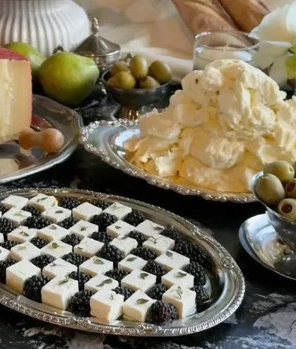 Mesa con quesos, uvas y aceitunas